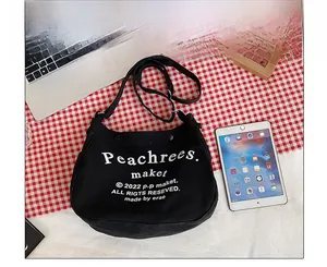 Detailed comparison of black canvas tote bag size relative to laptop and iPad