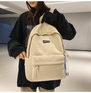 Detailed view of beige canvas backpack with durable fabric and woven label for students
