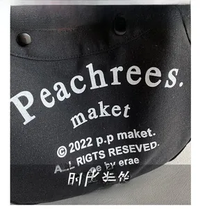 Close-up of black canvas texture with white Peachrees lettering and metal hardware detail