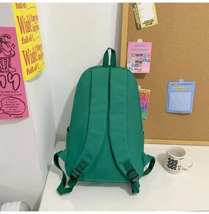 Detail view of emerald green backpack with wide ergonomic shoulder straps and top handle