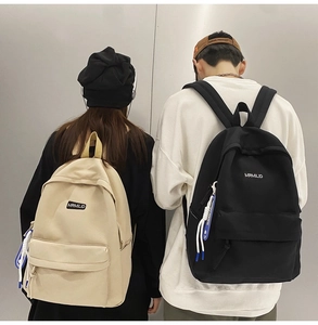 Detailed view of the woven lanyard accessory on minimalist student backpacks in white and black