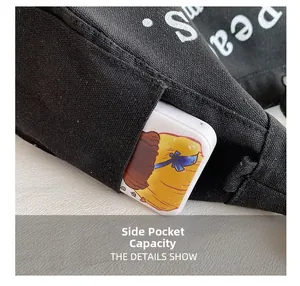 Detail of side pocket on black canvas bag showing storage capacity with cartoon power bank