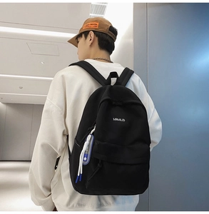 Minimalist black nylon backpack with white text print and blue paracord keychain detail