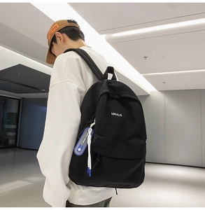 Detailed side view of black minimalist backpack with sporty blue zipper pendant and logo
