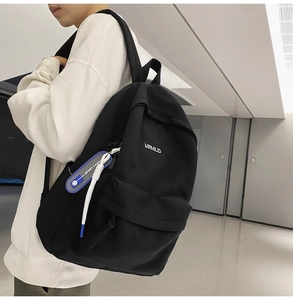 Side view of black minimalist backpack with letter patch and blue sport fashion lanyard