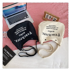Flat lay of black and cream canvas tote bags with Peachrees print on checkered cloth