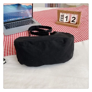 Detailed view of spacious black canvas crossbody bag bottom with adjustable nylon strap