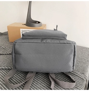 Detail view showing reinforced bottom and grey woven straps of the durable fabric backpack