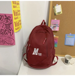 Detail view of burgundy large capacity school backpack with logo and side pocket