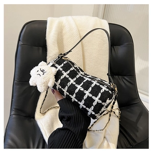 Detail of checkered barrel bag with chain strap and cute star plush pendant accessory