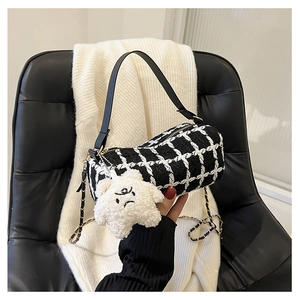 Detail of tweed checkered barrel bag with chain strap and cute star plush charm
