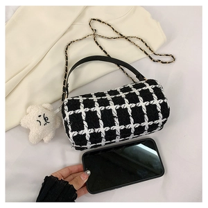 Detail of checkered tweed Boston bag with leather handle and metal chain strap