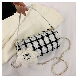 Detail of tweed checkered mini bag with leather handle and plush star pendant