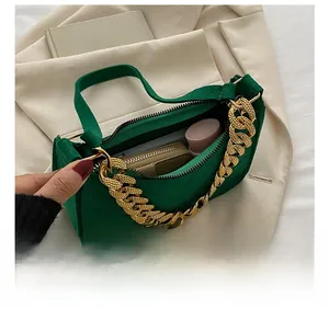 Macro detail showing interior capacity of green felt baguette bag with gold chain