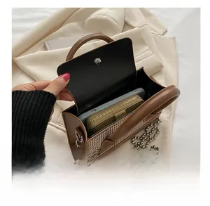 Internal view of houndstooth crossbody bag showing storage space for phone and wallet