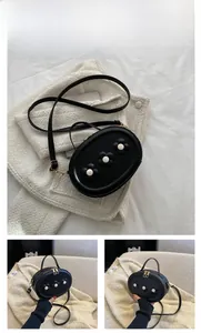 Détail du mini sac noir en cuir PU pour fille avec fleurs 3D blanches et fermeture dorée