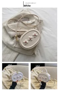 Détail du mini sac à fleurs blanc avec doubles fermetures éclair dorées et cuir PU lisse
