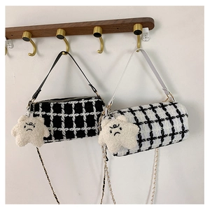 Close-up of checkered tweed cylinder bags with plush star charms and golden chain straps