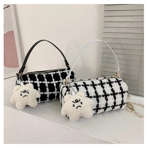 Detail of checkered barrel bags with plush star charms and dual color shoulder straps