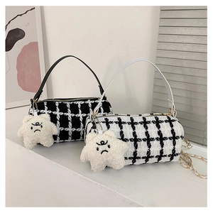 Detail of checkered tweed cylinder handbags with gold chain and star plush charm