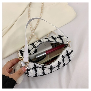 Detail of tweed crossbody bag interior showing storage space for phone and lipstick