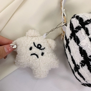 Detail of white star plush charm with embroidered smiley face and metal ball chain