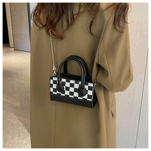 Detailed view of women's checkerboard crossbody bag with chain strap and dual handles