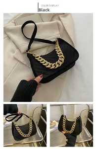 Close-up of black felt baguette bag featuring V-shaped quilting and gold chain strap