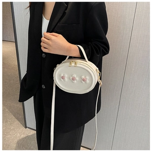 Sac à bandoulière blanc pour fille avec fleurs roses porté par un mannequin