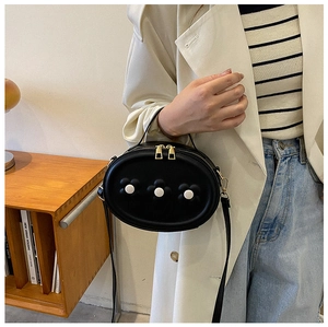 Détail du petit sac noir à fleurs avec double fermeture éclair et bandoulière