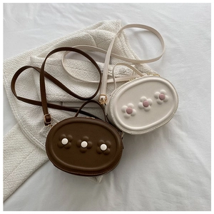 Détail de mini sacs bandoulière en PU avec accents floraux 3D en marron et crème