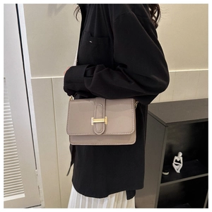 Détail de profil du sac bandoulière beige en similicuir avec boucle dorée élégante