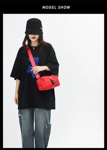 Detail of red nylon crossbody bag featuring durable buckle and adjustable strap on model