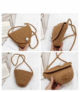 Détails montrant le tissage en paille en spirale et le grand fermoir perle du mini sac
