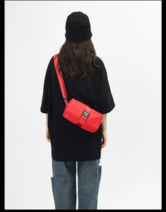 Detail view of the bright red Oxford cross-body bag with large black buckle on back
