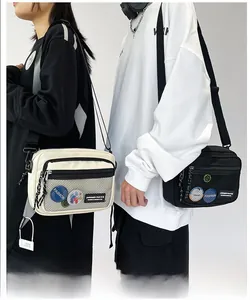 Detail of canvas messenger bags with front mesh pocket and decorative badges