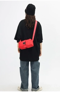Detail of red oxford fabric crossbody bag with wide adjustable shoulder strap buckle