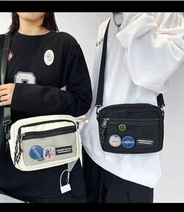 Detail of canvas crossbody bags with dual-layer mesh pockets and decorative badges