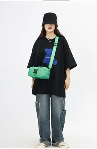 Street style view of vibrant green nylon messenger bag with adjustable shoulder strap