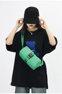 Detail of green nylon crossbody bag showing secure black buckle and adjustable strap