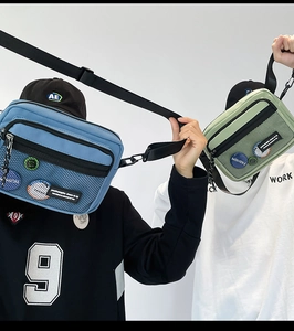 Detail of blue and green nylon messenger bags with mesh pockets and fashion patches