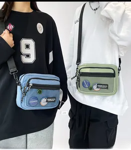 Detail view of retro canvas messenger bags in blue and green with mesh pockets and adjustable straps