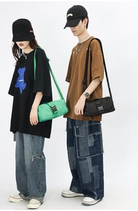 Detail of nylon cylinder crossbody bags in green and black with buckle straps