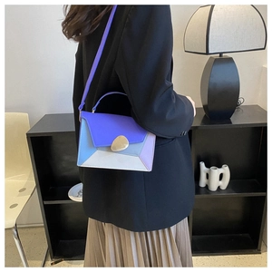 Detail of color-block flap bag with gold pebble buckle and slim purple shoulder strap