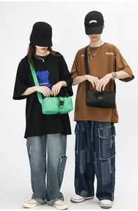 Nylon messenger bag in green and black with adjustable straps and buckle closure