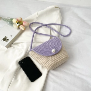 Détail d'un sac bandoulière tissé main avec rabat violet, bouton perle et décor tulipe