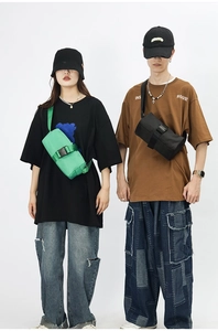 Detail view of Oxford cloth crossbody bags in green and black with plastic buckle straps