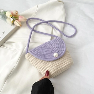 Détail du sac bandoulière tricoté violet et beige avec une grande perle sur le rabat