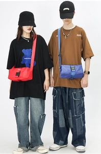 Detail of red and blue nylon crossbody bags with adjustable straps and front buckles