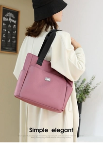 Détail du grand sac cabas Oxford vieux rose avec logo argenté porté par un mannequin